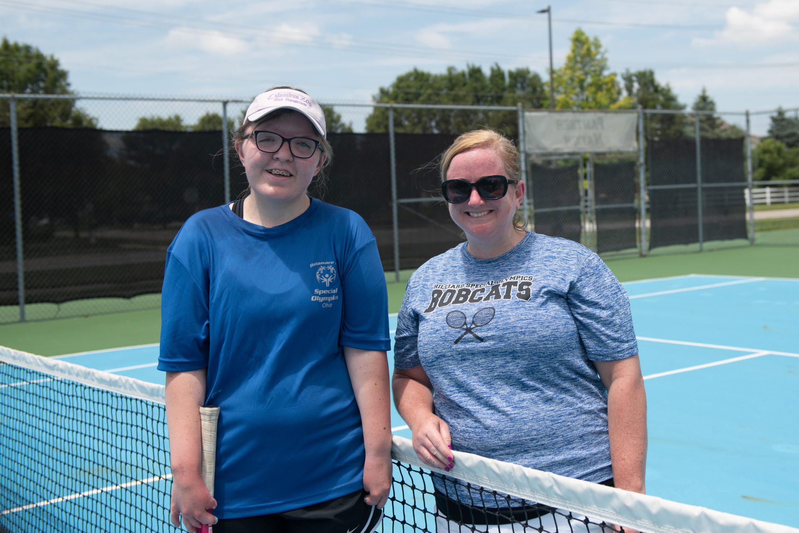 Women on tennis court wearing blue shirts | Unified Champion Schools | Special Olympics Ohio 