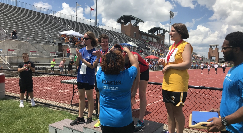 People in blue shirts at a track meet | volunteer form | Special Olympics Ohio